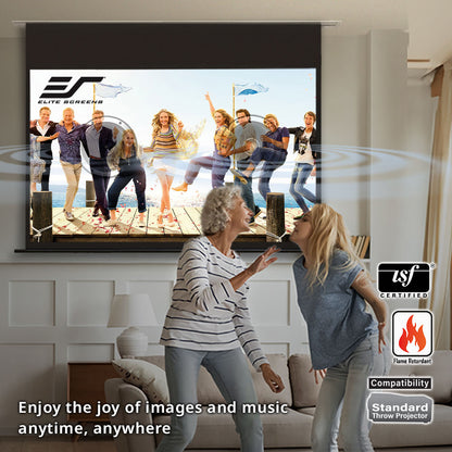 Two women dancing in a living room with a large screen displaying a family on a dock.