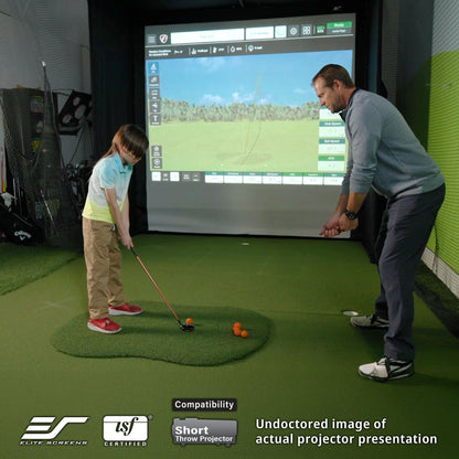 Two people playing golf on a simulator with a screen displaying a golf course.