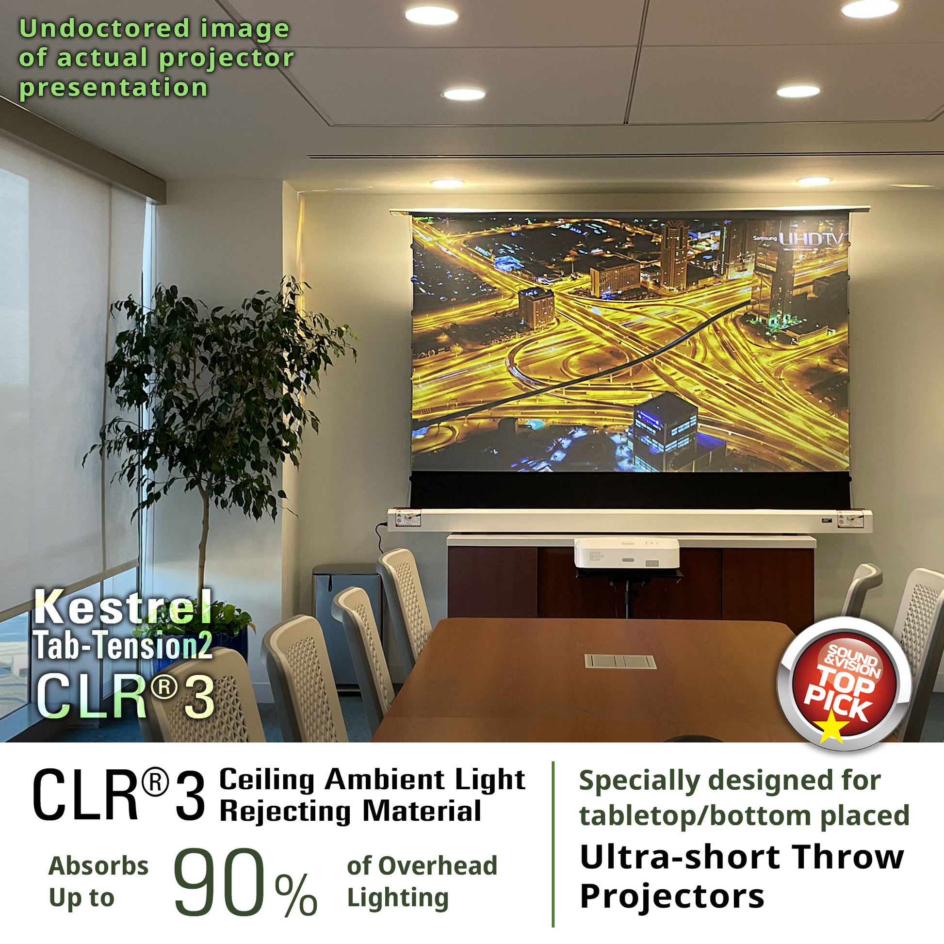 Conference room with a projector screen displaying a cityscape, featuring Kestrel CLR 3 ceiling light rejecting material.