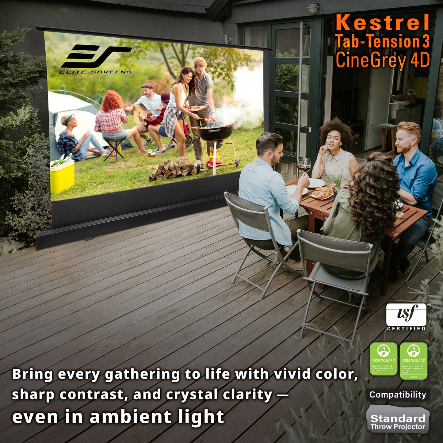 Outdoor setting with people gathered around a table, watching a large screen displaying an outdoor scene. Kestrel Elite Screens Tab-Tension3 CineGray 4D projector screen is visible.