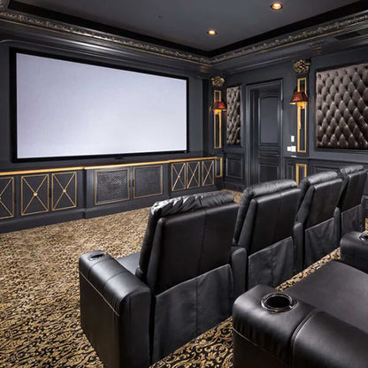 Luxury home theater with black leather seats and a large screen.