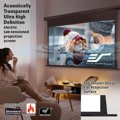 Woman sitting in a living room with an Elite Screens projection screen displaying a person holding a knitted item.