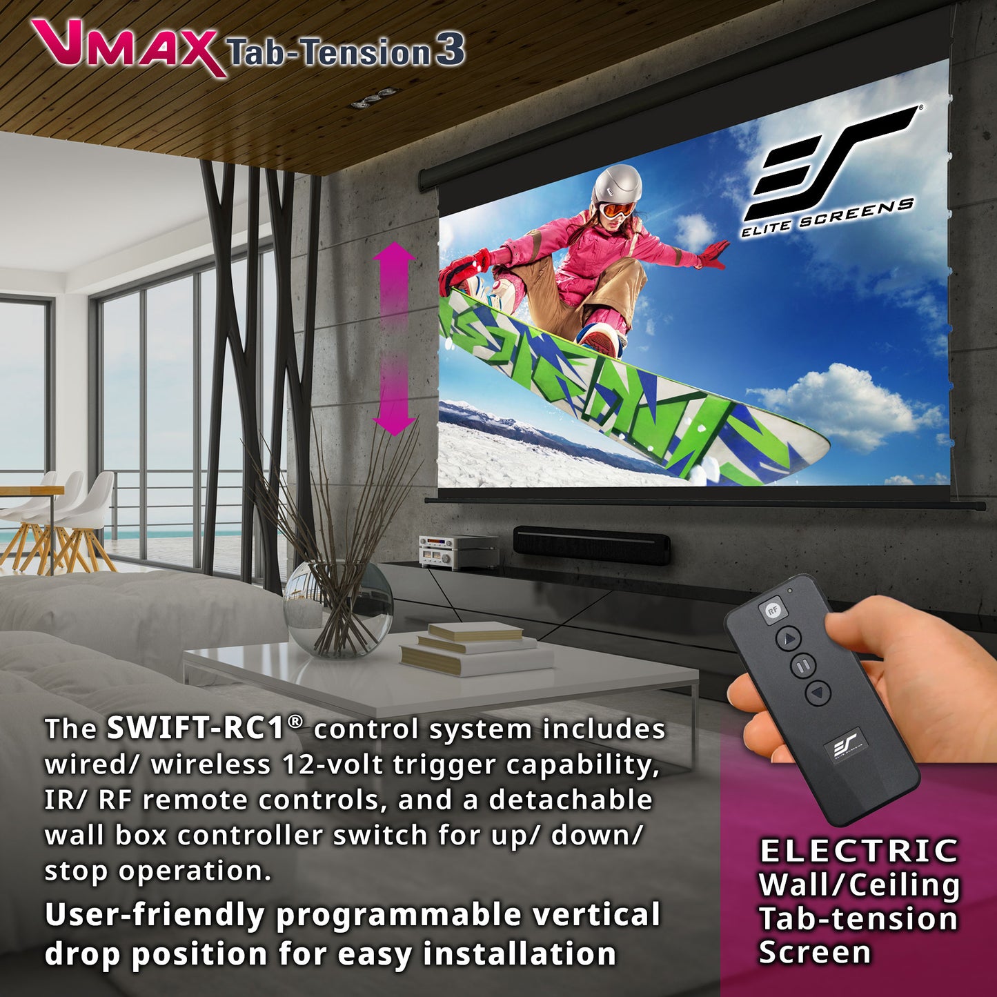 Living room with electric wall/ceiling tab-tension screen displaying a snowboarder, remote control held by hand, and VMAX Tab-Tension 3 CineGrey branding.